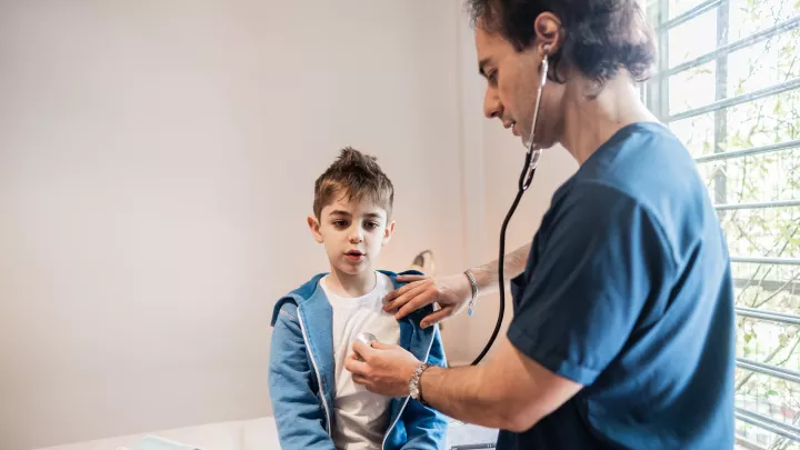 male_doctor__listening_boy_heart_stethescope_