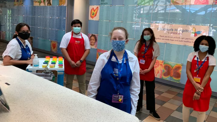 Image of smiling volunteers wearing respiratory masks and aprons.