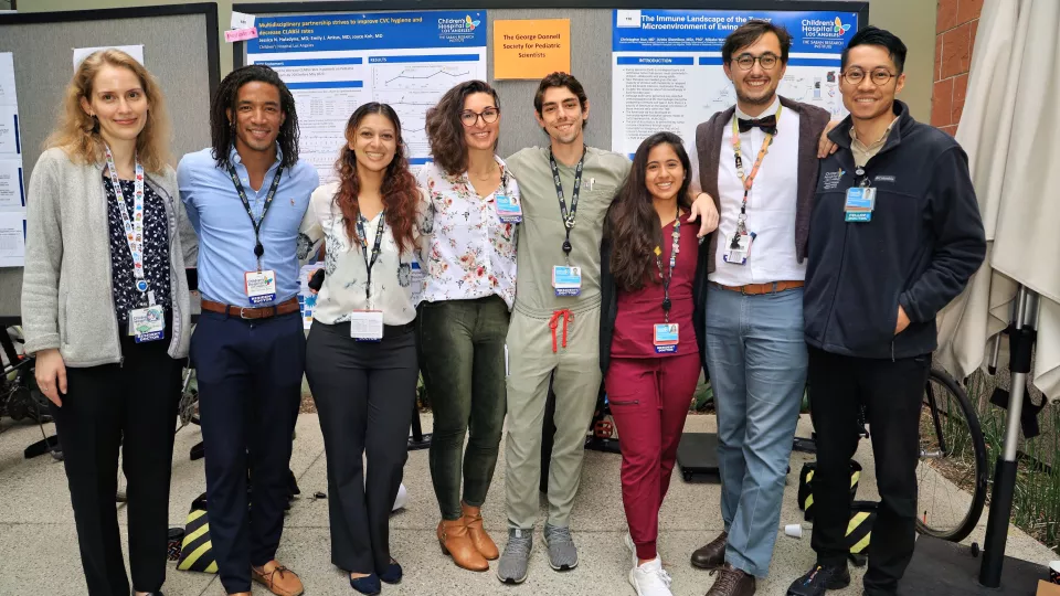 Eight casually dressed members of the George Donnell Society for Pediatric Scientists pose for a team picture