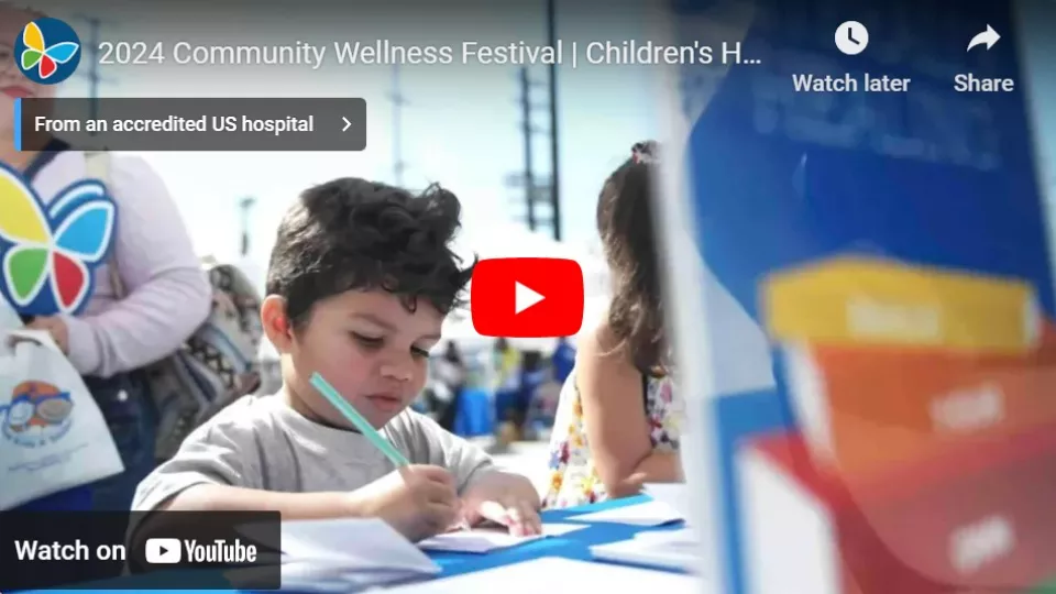 Young boy with medium skin tone and dark hair draws at a table in YouTube player screengrab of CHLA's 2024 Community Wellness Festival