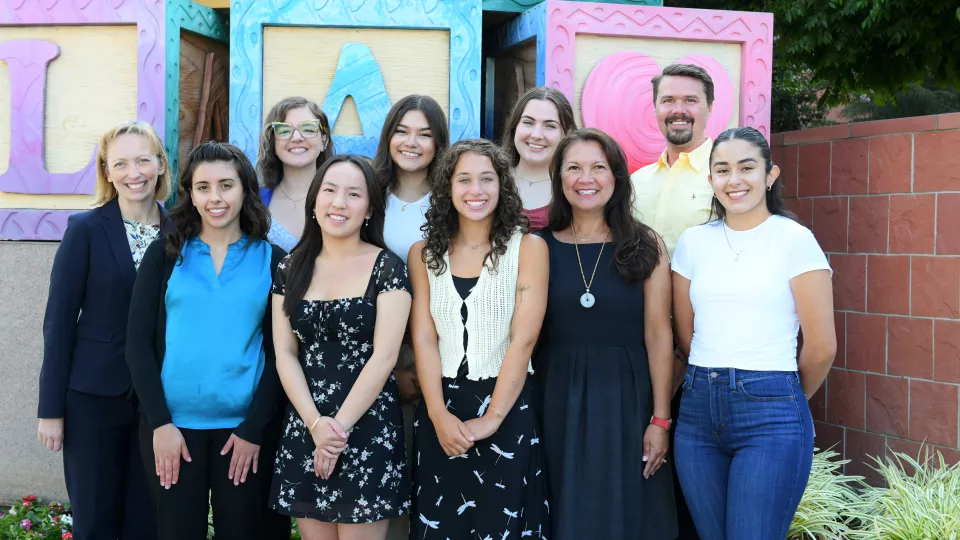 Pediatric Pathway Program participants pose with CHLA nursing leaders and Mount Saint Mary's staff in front of the CHLA blocks sculpture. 