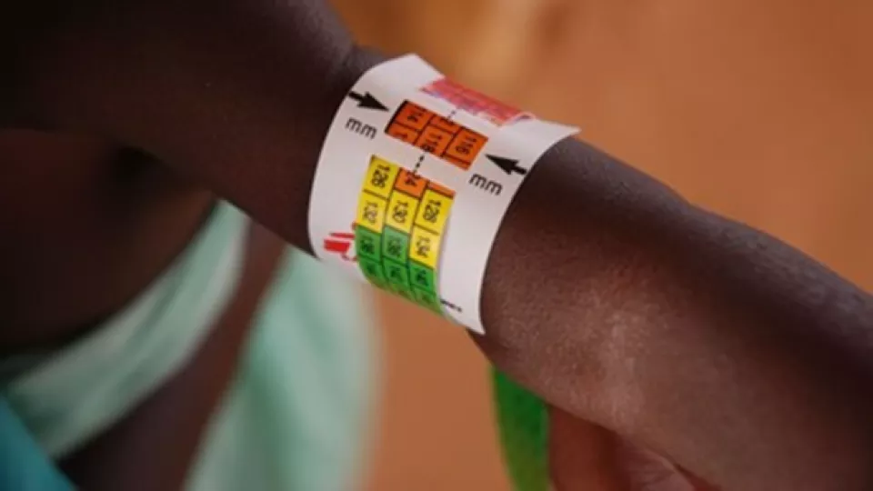 Brightly colored medical band measuring circumference of patient's arm