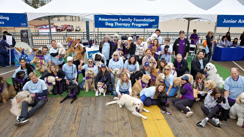 A group of dog therapy volunteers pose together at Walk and Play L.A. 2024. 