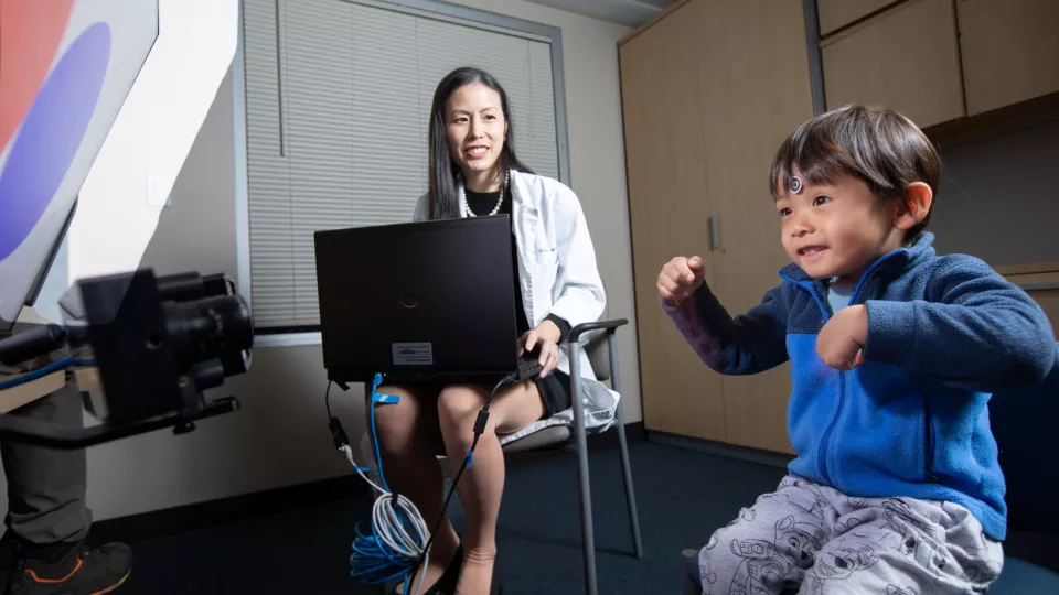 Dr. Melinda Chang in white labcoat vision tracking young Asian boy