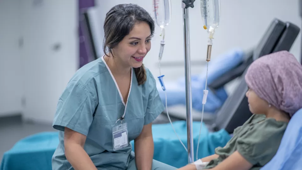 Woman in scrubs comforts a young patient.