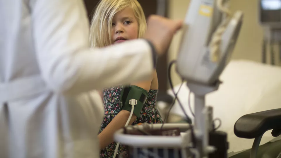 Child at doctor's office wearing a blood pressure cuff