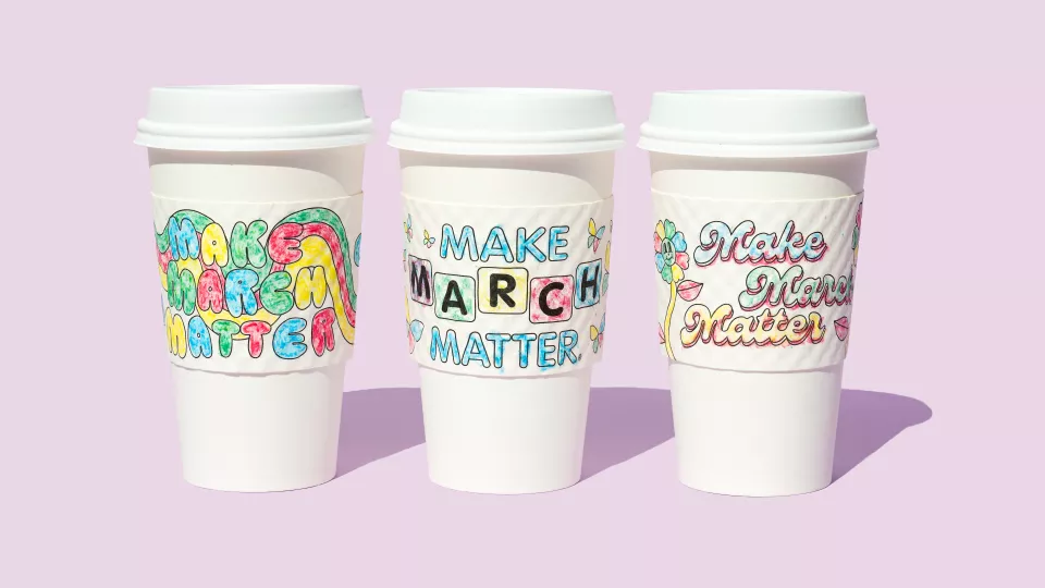 Three to-go coffee cups with brightly colored Make March Matter sleeves against a pink background