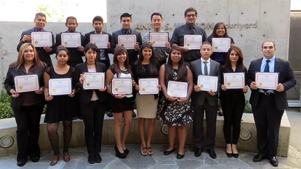 Two rows of professionally dressed young men and women holding certificates