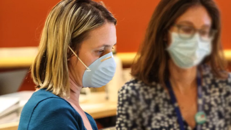 Two women wearing respirators.