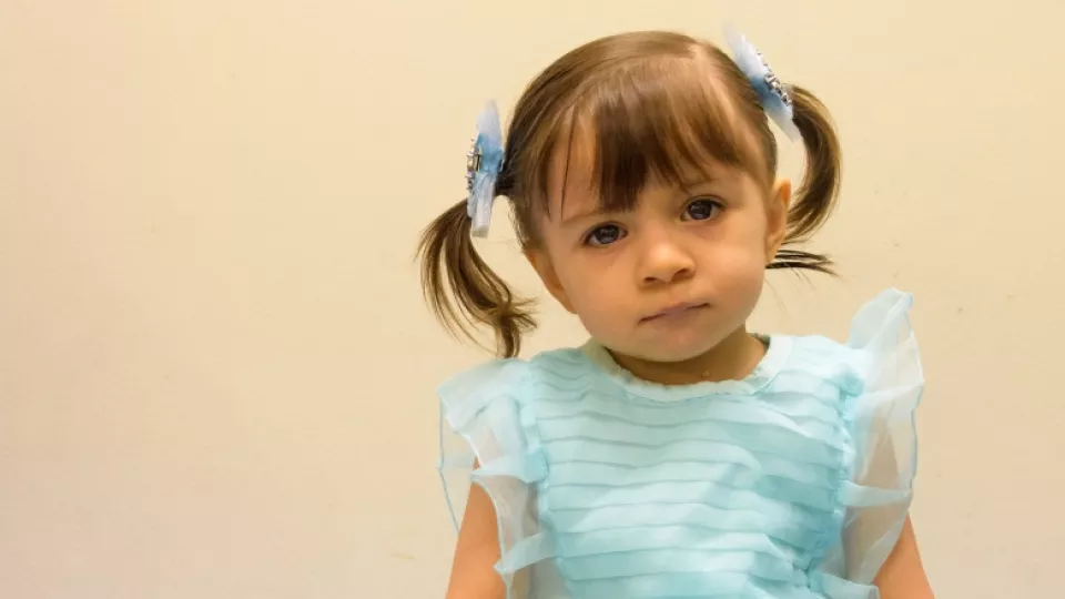 Portrait of Angelique Garcia, a female toddler wearing a light blue colored dress.