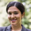 Headshot of woman with light skin tone and dark hair wearing business attire