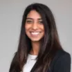 Headshot of woman with medium skin tone and dark hair wearing business attire