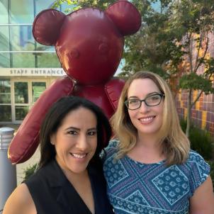 Talaya Martinez and Claire Baldauf stand together and smile at the camera in the CHLA courtyard. 