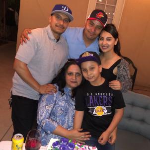 Family of five gathered around birthday cake