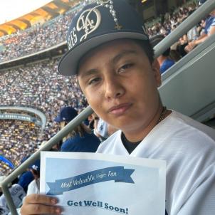 Adolescent boy wearing baseball cap and holding get-well-soon notice