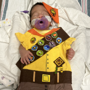 A NICCU baby wears a boy scout uniform from Pixar's film UP.