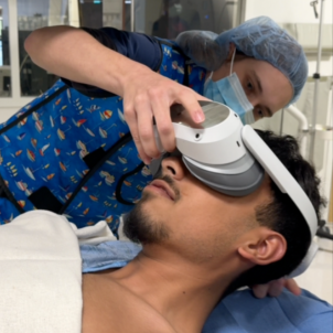 Hunt fits the VR goggles to a patient's head in pre-op. 