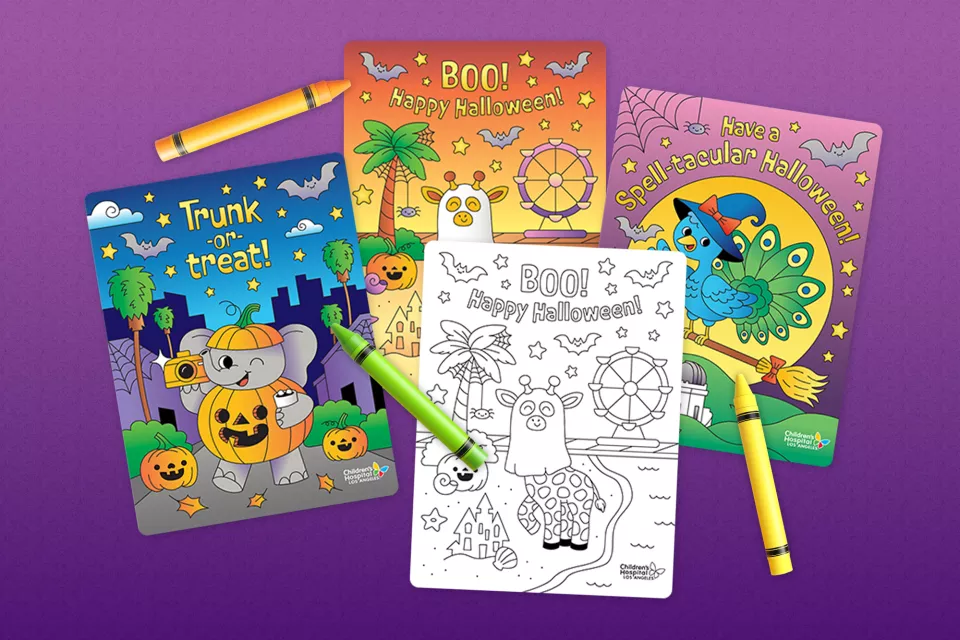 Brightly colored Halloween cards and crayons against a dark purple background