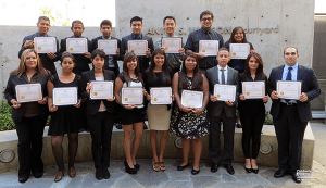 Two rows of professionally dressed young men and women holding certificates