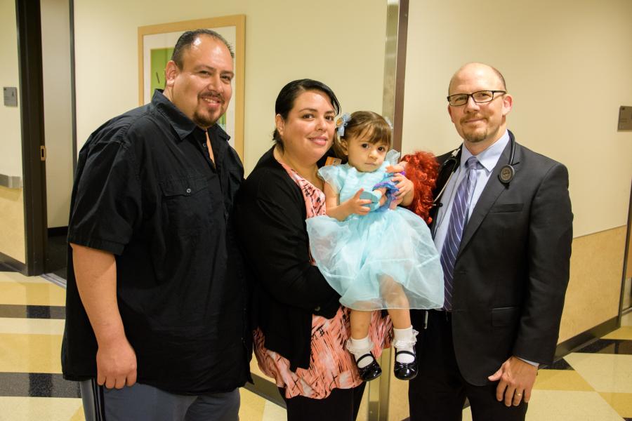 Angelique Garcia and her parents smile while posing with Dr. Pruetz.