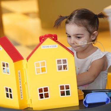 Emme playing with a toy house