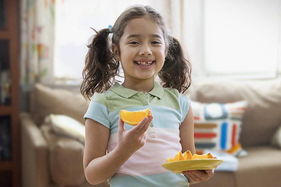 Girl eating orange slices